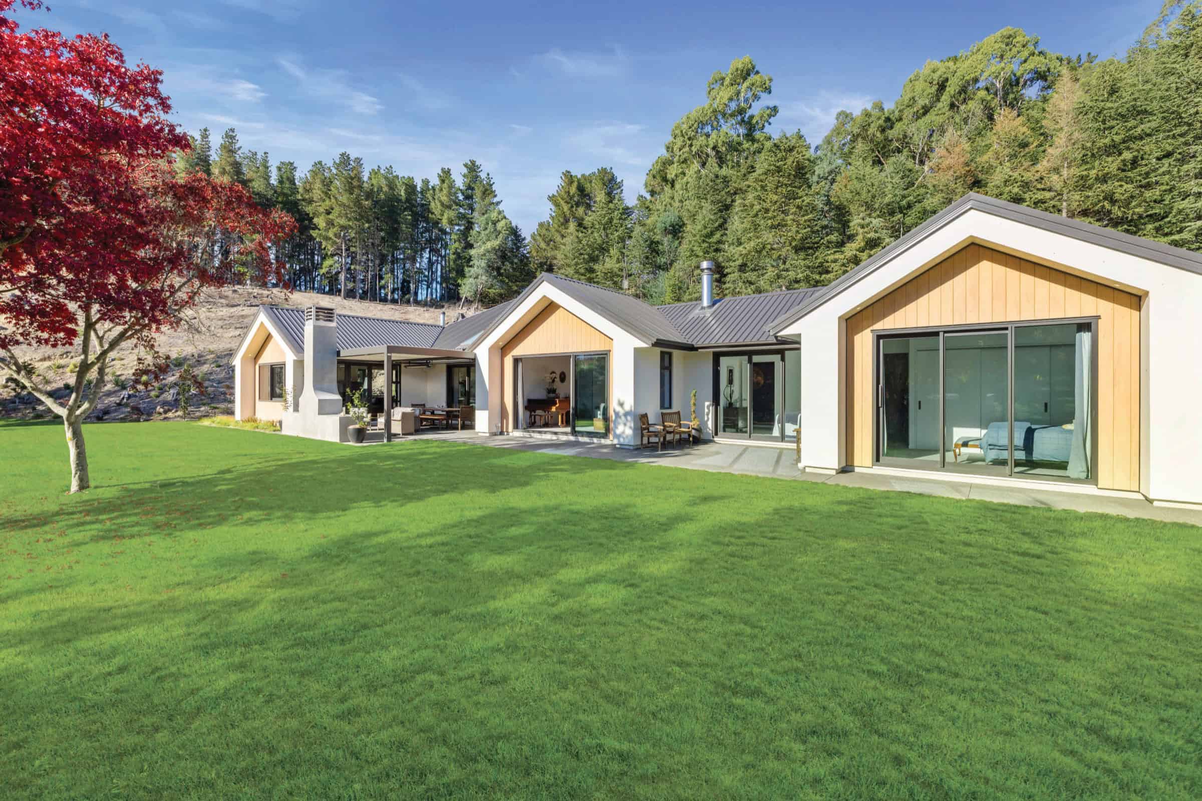 Rural homestead built by Coughlan Homes in North Canterbury, with a large lawn and native planting.
