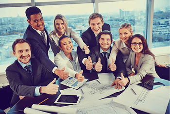 Diverse business team smiling and giving thumbs up in a modern office.