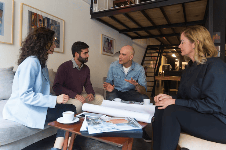 Group of people discussing home building plans indoors.