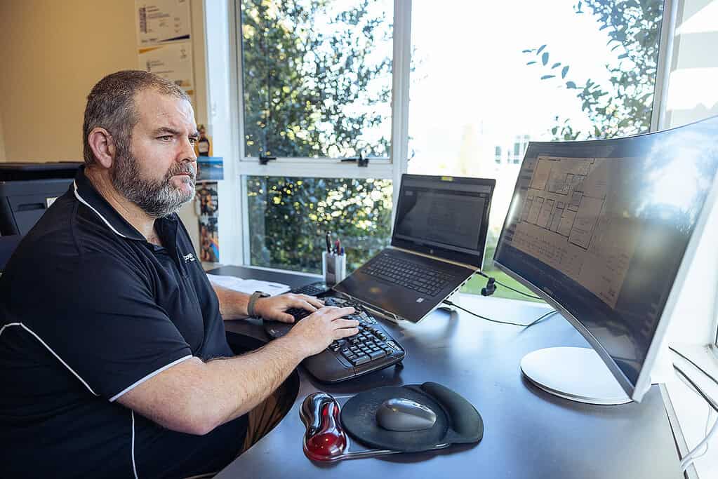 Coughlan Homes quantity surveyor preparing a fixed-price quote at his desk