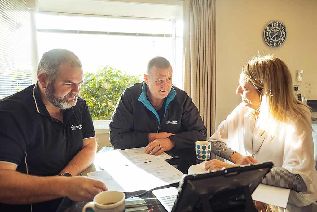 Coughlan Homes team sitting down with a client over plans at the initial consultation.