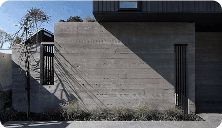 Board-formed concrete and dark-clad Coughlan Homes build in Christchurch.